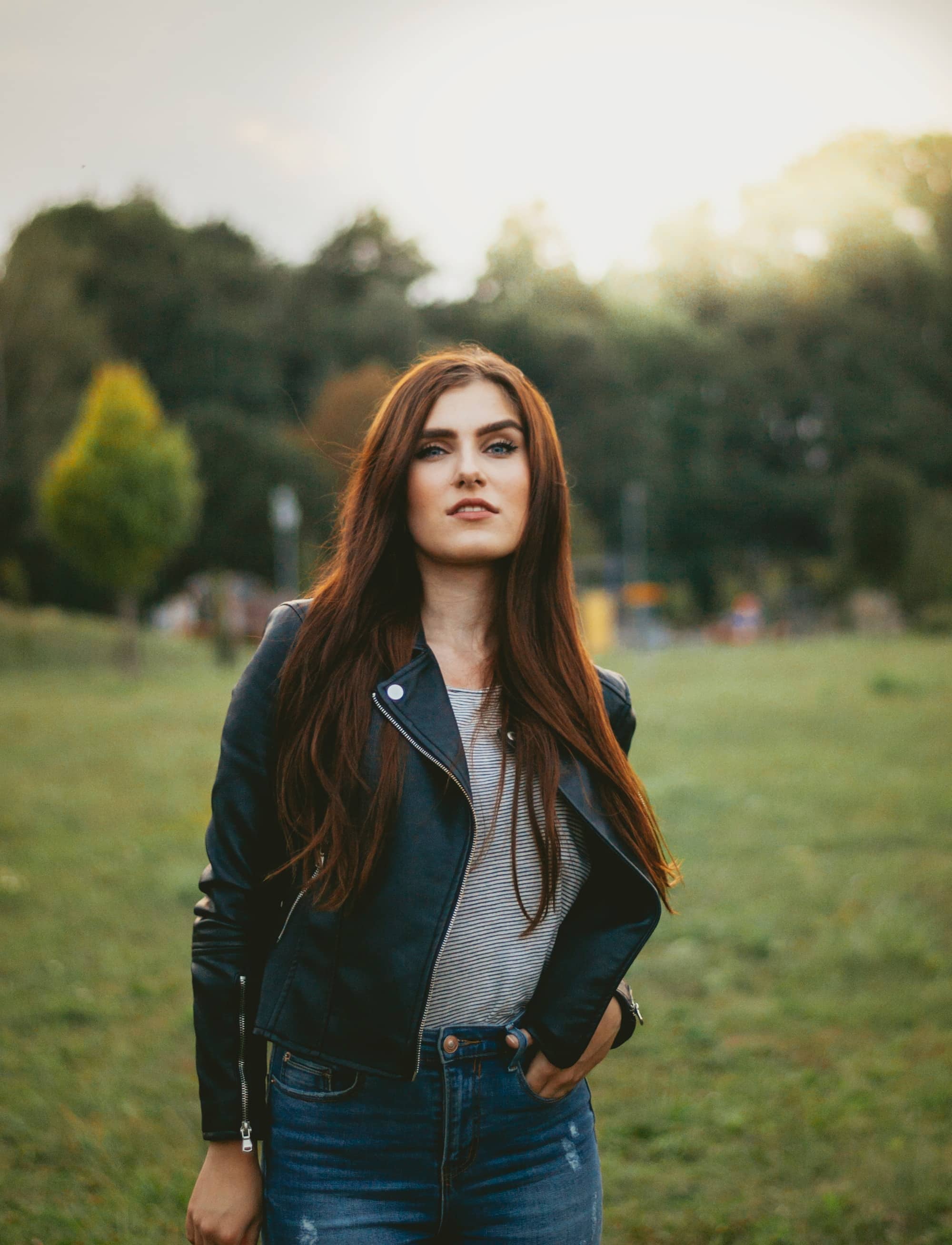 femme brune portant un jean un t-shirt rayé et une veste en cuir